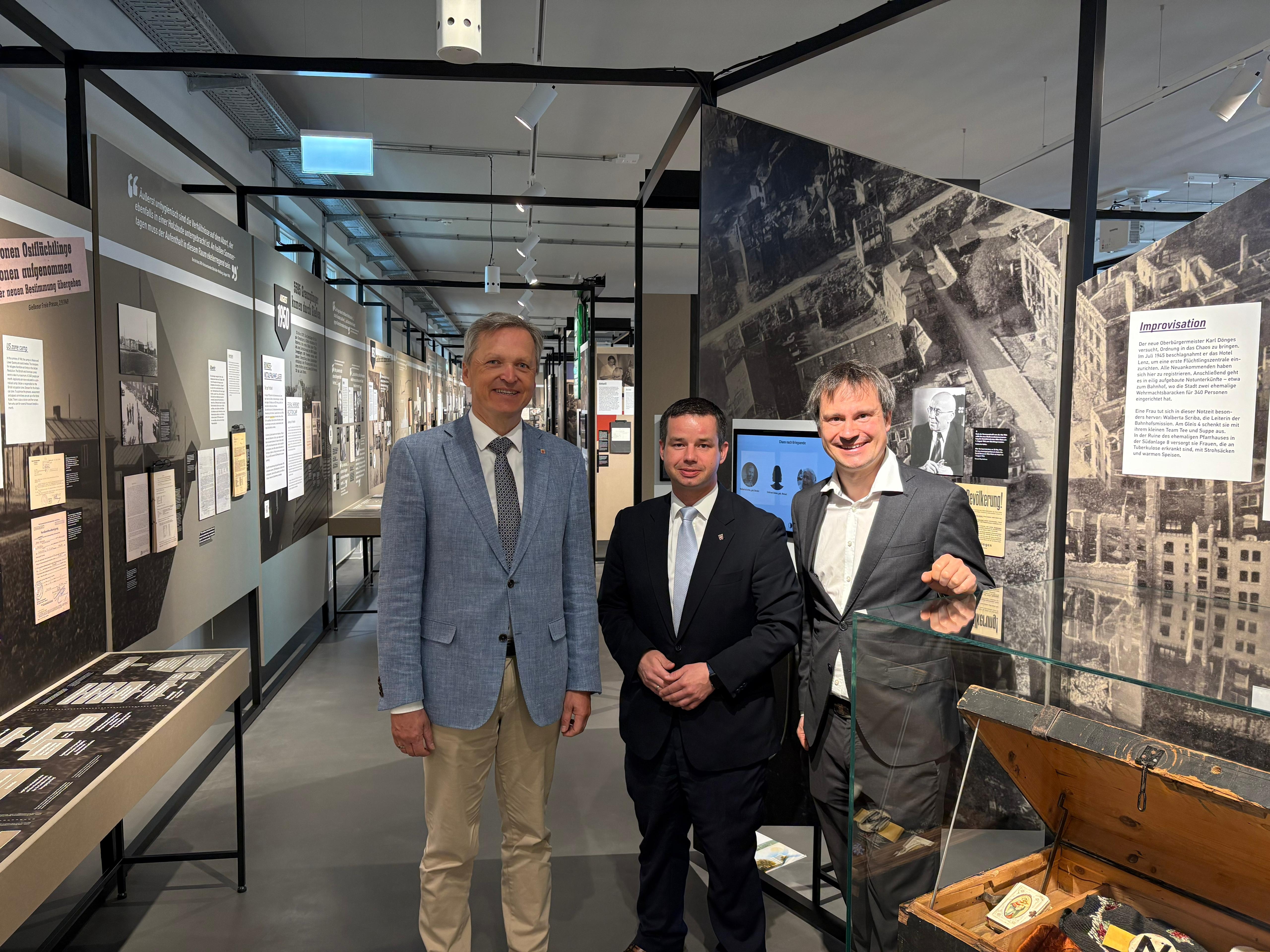 Innenstaatssekret�r Martin R��ler und der Hessische Landesbeauftragten f�r Heimatvertriebene und Sp�taussiedler Andreas Hofmeister MdL werden vom Gesch�ftsf�hrer des Lern- und Erinnerungsorts Notaufnahmelager Gie�en, Dr. Florian Greiner, durch die Ausstel