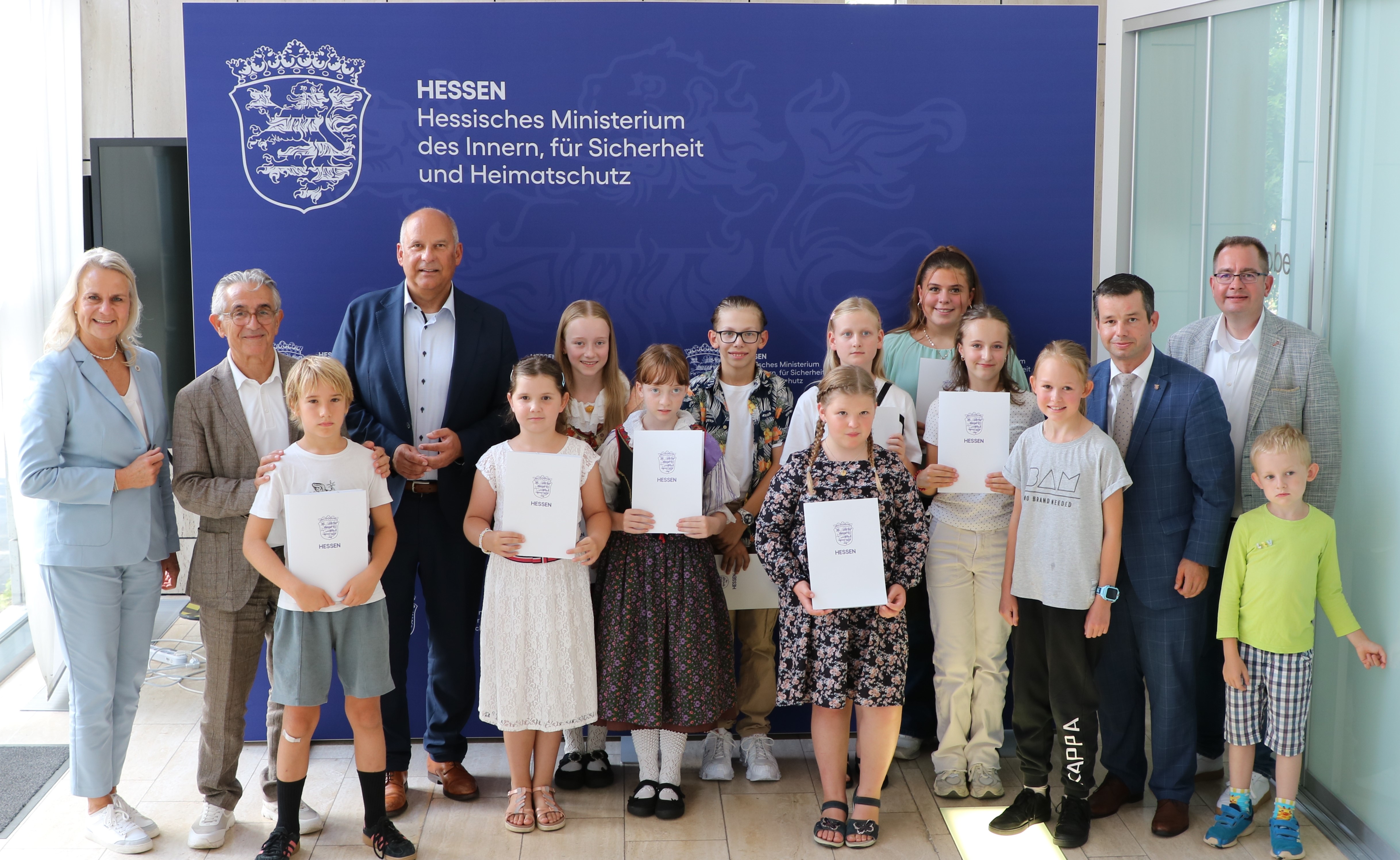 Innenminister Roman Poseck und Landesbeauftragter Andreas Hofmeister gemeinsam mit den Preistr�gerinnen und Preistr�gern des ersten hessischen Malwettbewerbs �Heimat aus junger Perspektive: Erinnern. Erz�hlen. Malen.� Des Weiteren: Frau Abgeordnete und UH